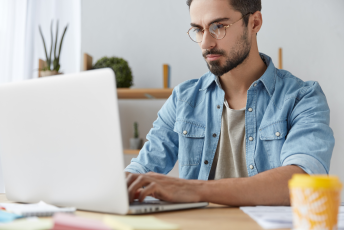 Serious,Male,Model,Wears,Denim,Shirt,And,Glasses,,Checks,Emails